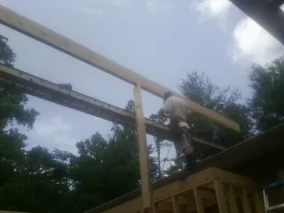 Carpenter setting a ridge beam over a new addition frame — Ice Dam Removal by Roofing Brothers in Shenandoah