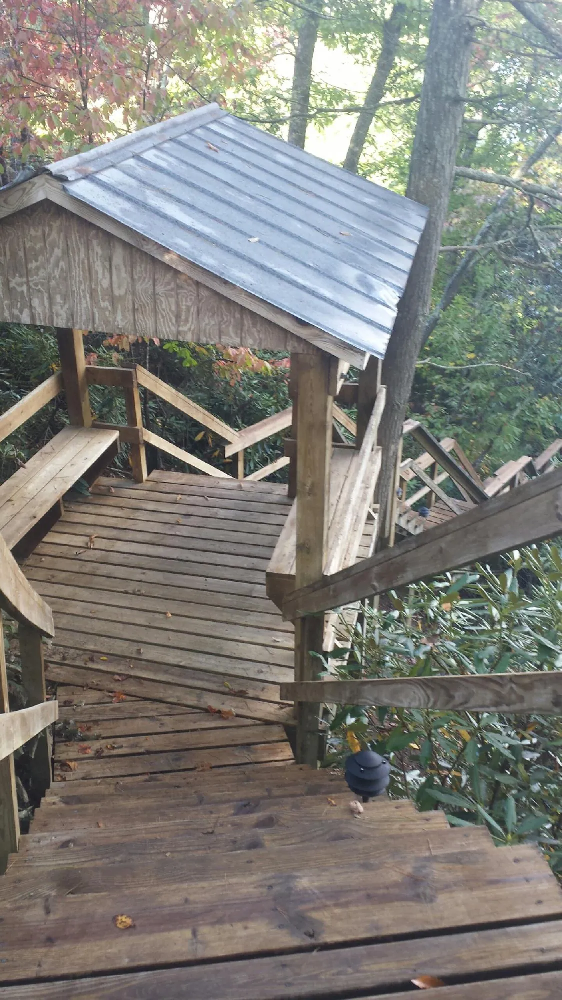 Metal roofed shelter over wooden steps on a wooded walkway — Skylight Repair & Installation work by our crew in Shenandoah